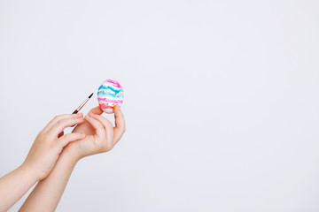 Happy Easter concept.Art and craft concept with child's hands and paiting eggs isolated on a white background.