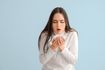 Coughing young woman on light background