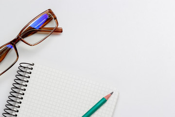 notebook, pencil and glasses on white background isolated
