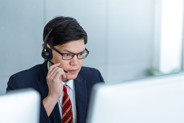 Call center man working care customer service wearing headphone talking .with customer at call...