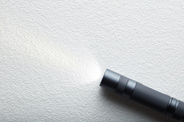 Black flashlight with a beam of light on White background