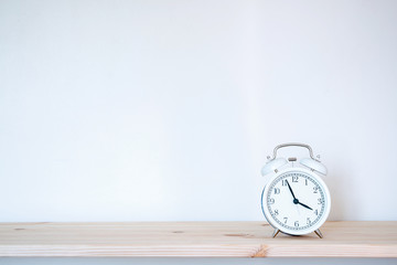 White retro alarm clock on brown wood desk