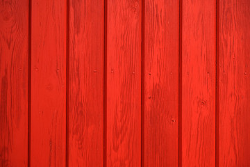 Old wooden background painted with red paint with a texture of cracks and scratches. Red background
