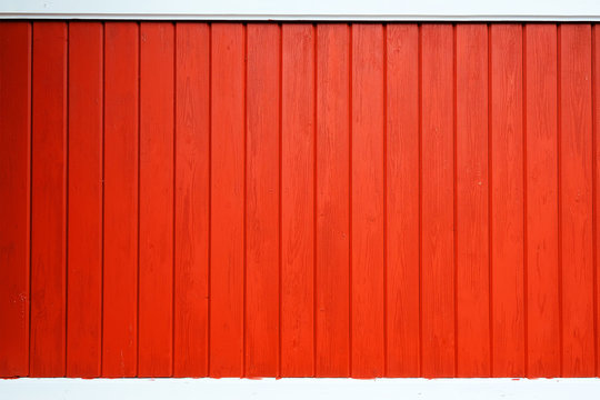 Old wooden background painted with red paint with a texture of cracks and scratches. Red background