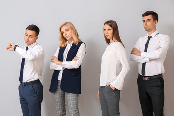 Obraz premium Young business people waiting in line on light background