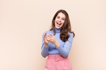 young pretty woman feeling happy and successful, smiling and clapping hands, saying congratulations...