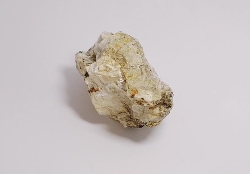 specimen of muscovite biotite granite stone on white background. mineral stone.