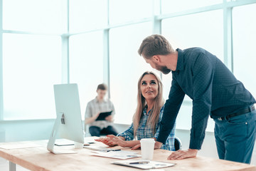 .smiling employees discussing online news in the workplace.