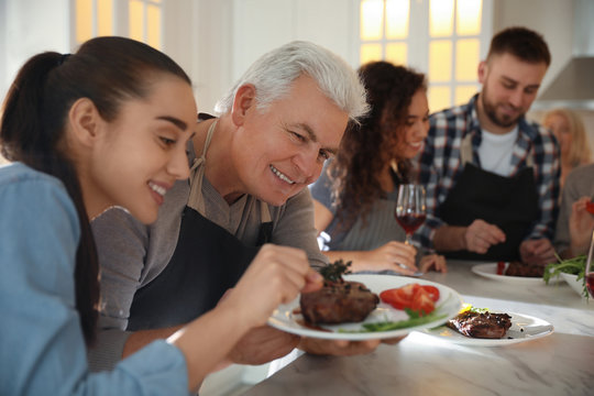 Happy people cooking food together in kitchen