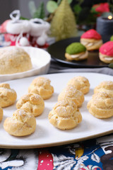 christmas choux cream or cream puff or French profiteroles with fresh cream set on cafe table.