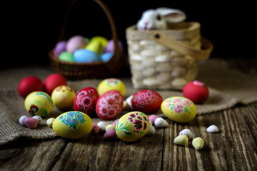 Easter composition on wooden background with rabbit figure. Hand painting Easter eggs. The concept of religious holidays, family traditions. Selective focus.