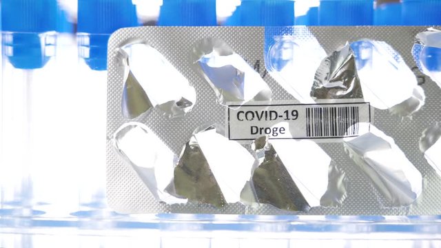 27948_The_drug_Covid-19_Droge_written_in_German_pack_being_peeled_off_for_coronavirus.mov