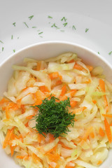 white cabbage carrot salad dressed with oil and decorated with dill