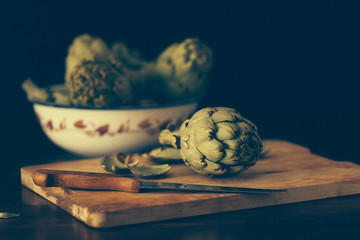 Alcachofas en la cocina sobre tabla para cortar