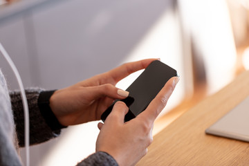 Close up of woman using smart phone at home