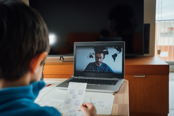 Child studying homework math during his online lesson at home, social distance during quarantine. Self-isolation and online education concept caused by coronavirus pandemia