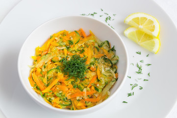 salad of grated cucumber, carrot, daicon, and pumpkin dressed with oil and lemon juice and decorated with dill and lemon
