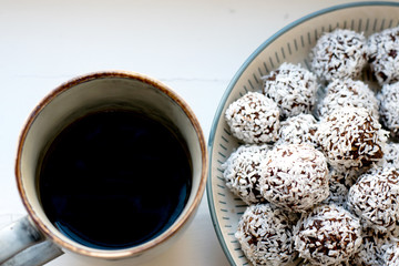 Cup of black coffee and a plate full of homemade chocolate balls, which is a classic no bake pastry...