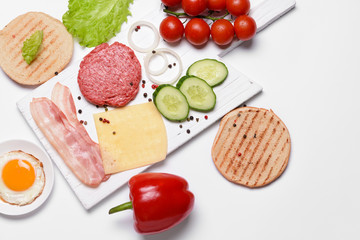 Ingredients for tasty burger on white background