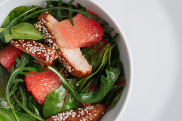 honey soy chicken, grapefruit, and leaf vegetables salad dressed with oil and vinegar 