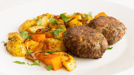 fried cutlets with roasted in spices potato and pumpkin
