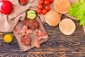 Ingredients for tasty burger on wooden table