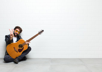 young cool musician man, playing rock and roll music sitting on the floor