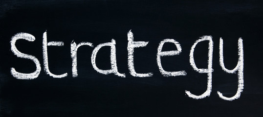 STRATEGY - in a title word for business coaching, mentoring, strategy, planning, inspiration, concepts & ideas - in panorama / header / banner, written in real chalk letters on a chalkboard.