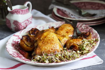 Baked chicken with apples, served with sprouted seeds and sauce.