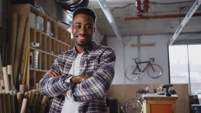 Portrait of young male business owner in workshop for building sustainable handmade bamboo bicycles - shot in slow motion  