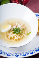 White bowl of egg noodle soup