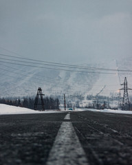 Scenic view on the dark empty road at the Norilsk in the Putorana Mountains during the Winter. North road