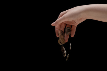 ruble coins fall from the hand down on a black background, the concept of the ruble's depreciation, economic crisis, recession and impoverishment