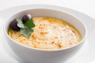 hummus bowl decorated with olives and parsley