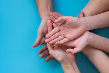 Family holding empty hands on blue background. Top view