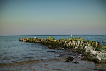 view of the rocky beach of the sea or ocean in sunny weather with clear blue sky