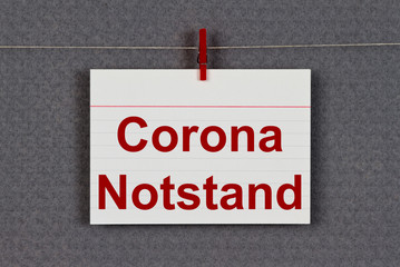 CORONA emergency written on a sticky note on a pin board