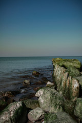view of the rocky beach of the sea or ocean in sunny weather with clear blue sky