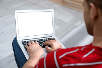 Man working on modern laptop at home, closeup