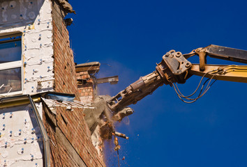Naklejka premium A demolition of a building with a crane with a blue sky background