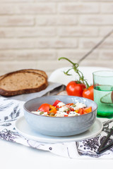 Fresh healthy salad with tomatoes, grilled pepper, cheese, pumpkin seeds and black sesame.