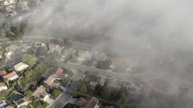 Morning mist over neighborhood of houses, aerial view