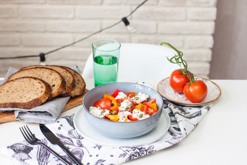 Fresh healthy salad with tomatoes, grilled pepper, cheese, pumpkin seeds and black sesame.