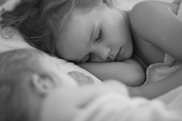 sister sleep together in bed home