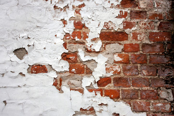 White and red. Brick wall with fragments of plaster close-up. Fragment of the old brickwork. Potholes and red brick defects.
