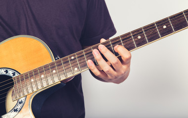 Fototapeta na wymiar man playing guitar acoustic wearing t-shirt close up shot on white background
