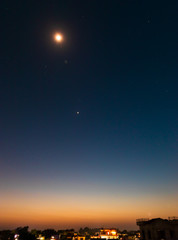 Surreal Twilight Colors. Long exposure of Lightburst Venus Planet with stars in the background and orange sky from setting sun. selective focus