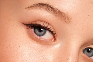 Fototapeta na wymiar Close up of female open eye. Clean skin. Blue eyes.Natural retouching. Arrows on the eyes 