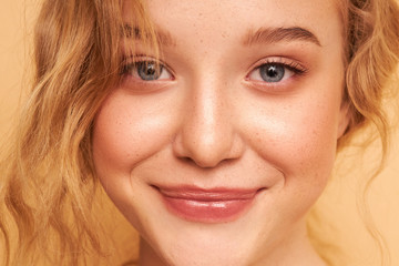 Portrait of young happy woman. Clean skin. Curly hair Blue eyes. Natural retouching 