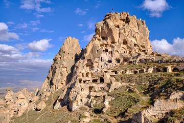 Uchisar Castle in Cappadocia, on a biright winter day, with blue sky and puffy clouds